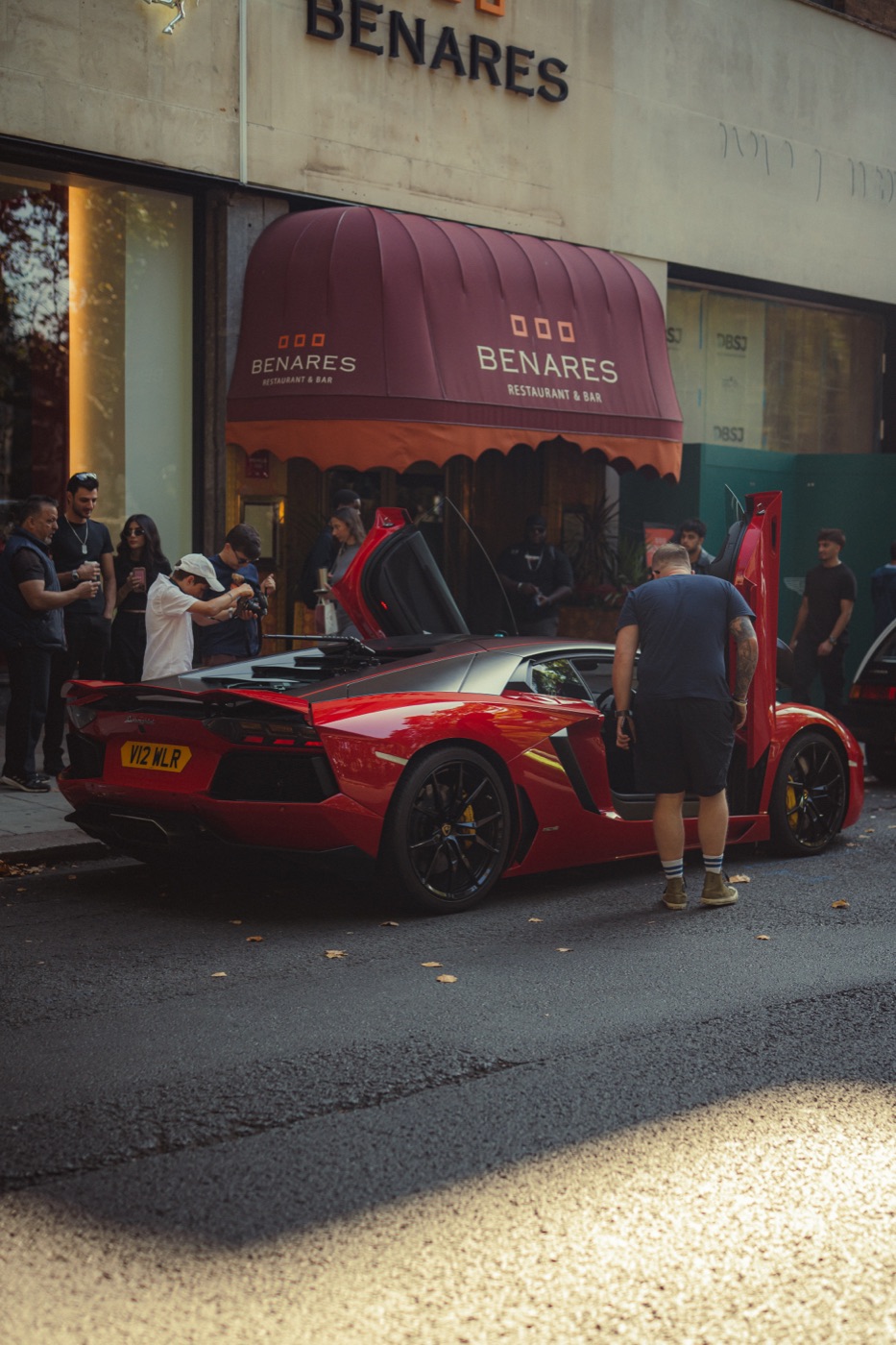 Red Lamborghini Aventador with doors up outside Benares